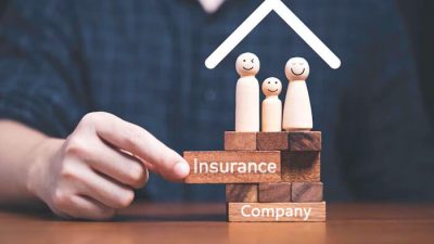 Visual concept showing wooden blocks labeled “Insurance Company” with a family figurine under a roof—symbolizing protection and guidance on how to start an insurance company.