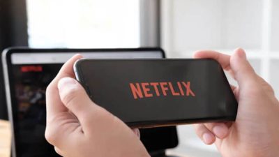 A person holding a smartphone displaying the Netflix logo, symbolizing online streaming and digital subscriptions — How to Pay Netflix via Mpesa Securely.
