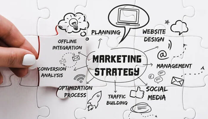 How to Start an Event Planning Business and Turn Your Passion into Profit - Finsurancebiz A hand placing the final puzzle piece labeled “Marketing Strategy,” surrounded by terms like planning, website design, and social media — illustrating key promotional steps in how to start an event planning business.