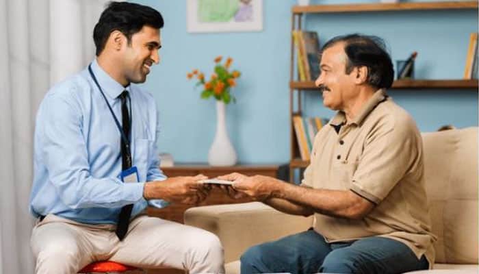 Florida Property Insurance News: Latest Updates, Reforms, and Market Trends - finsurancebiz - Finsurancebiz An insurance agent handing over documents to an elderly man, symbolizing the process of providing assistance and information for property insurance or policy services.