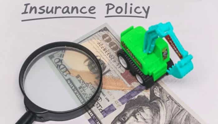 Types of Insurance: What You Need and Why - finsurancebiz - Finsurancebiz Types of Insurance: A toy excavator and magnifying glass placed on top of a dollar bill with the words 'Insurance Policy' written above, symbolizing insurance coverage.