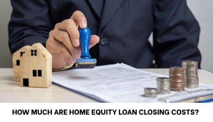 What Is the Interest Rate on a Home Equity Loan by Credit Score? - finsurancebiz - Finsurancebiz Home equity loan closing costs with lender reviewing documents beside a house model and coins